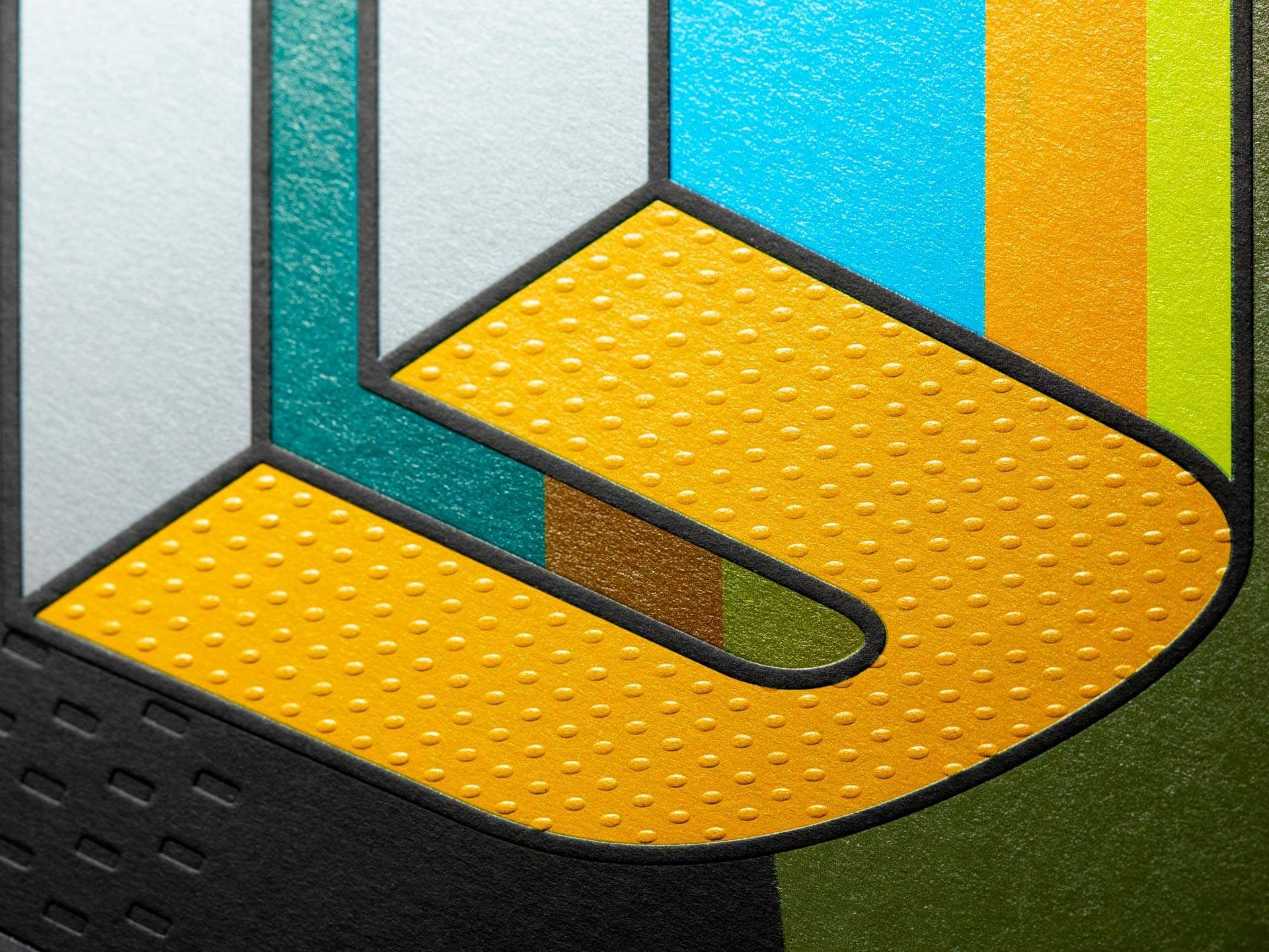 Un primo piano macro di una copertina stampata premium che mostra una lettera geometrica audace con texture a punti gialli goffrati, foglia metallica a strati ed effetti di bande multicolori in teal, giallo e arancione. Le tecniche di nobilitazione avanzate — goffratura, stampa a caldo e verniciatura UV — permettono ad imprenditori e aziende di creare stampati di marca straordinari.