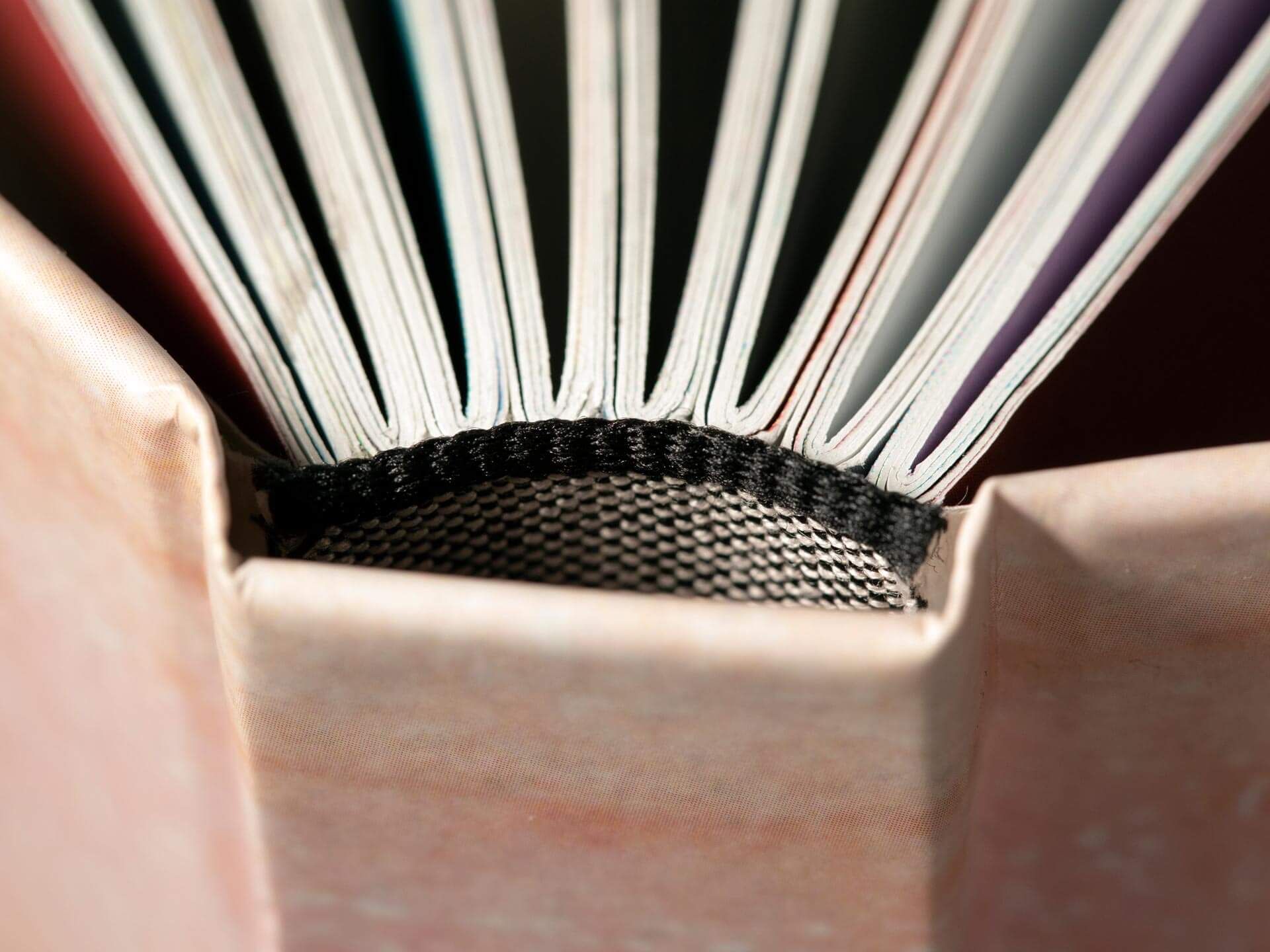 Primo piano macro dorso libro rilegato con rilegatura filo refe e. Macro dorso libro rilegato con rilegatura filo refe tradizionale e pagine bianche a ventaglio. Sprint24.