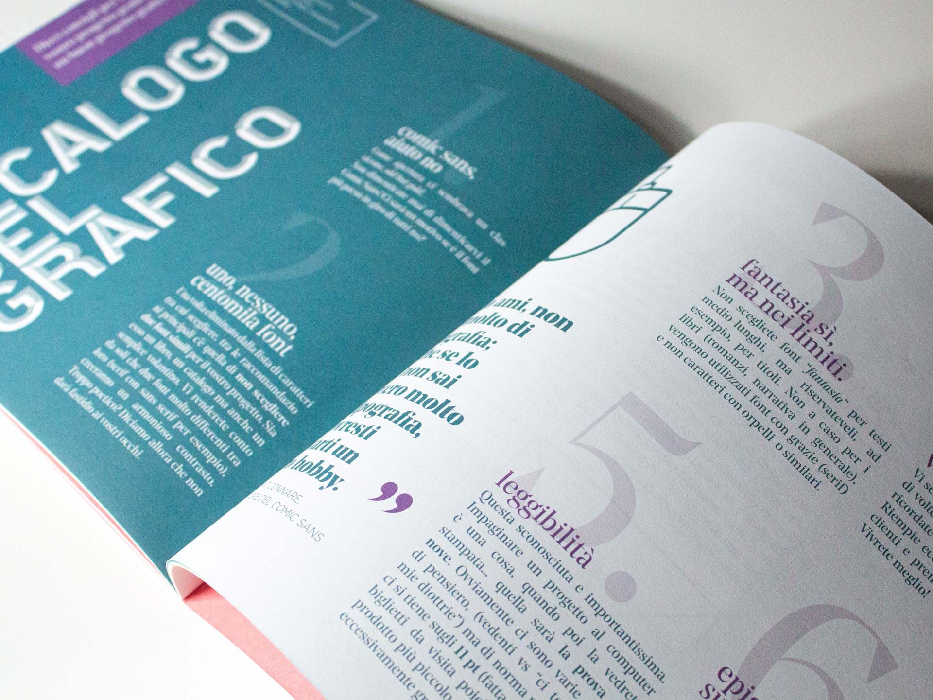 Un catalogo o rivista di design grafico 'Catalogo del Grafico' aperto con dorso di copertina teal audace e una doppia pagina con grandi intestazioni di sezione numerate, tipografia corsiva e layout editoriale multicolonna. L'impaginazione professionale per cataloghi, riviste e pubblicazioni di design grafico richiede competenze specialistiche — ottenibili attraverso servizi professionali di proge…