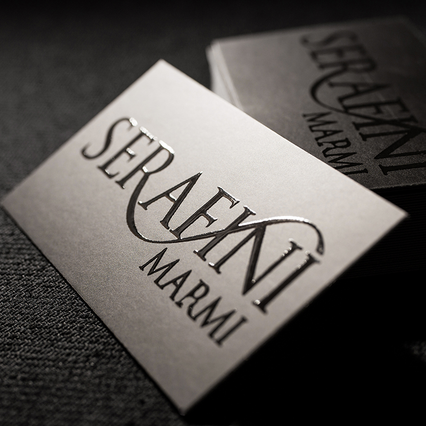 Due biglietti UV classici Serafini Marmi con logo argento lucido in rilievo su antracite opaco. Sprint24.
