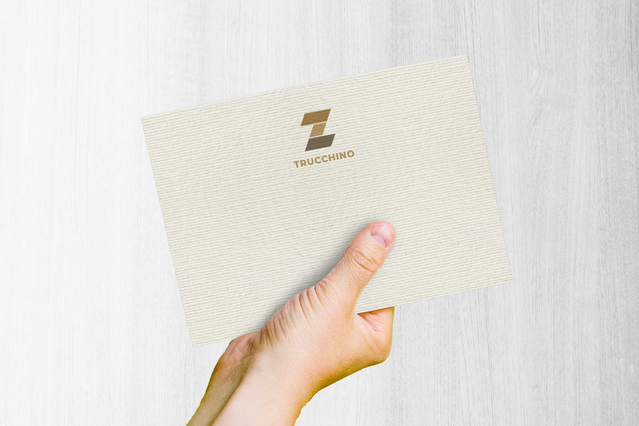 Mano con busta Acquerello Avorio con logo oro su carta testurizzata. Stampa premium Sprint24.